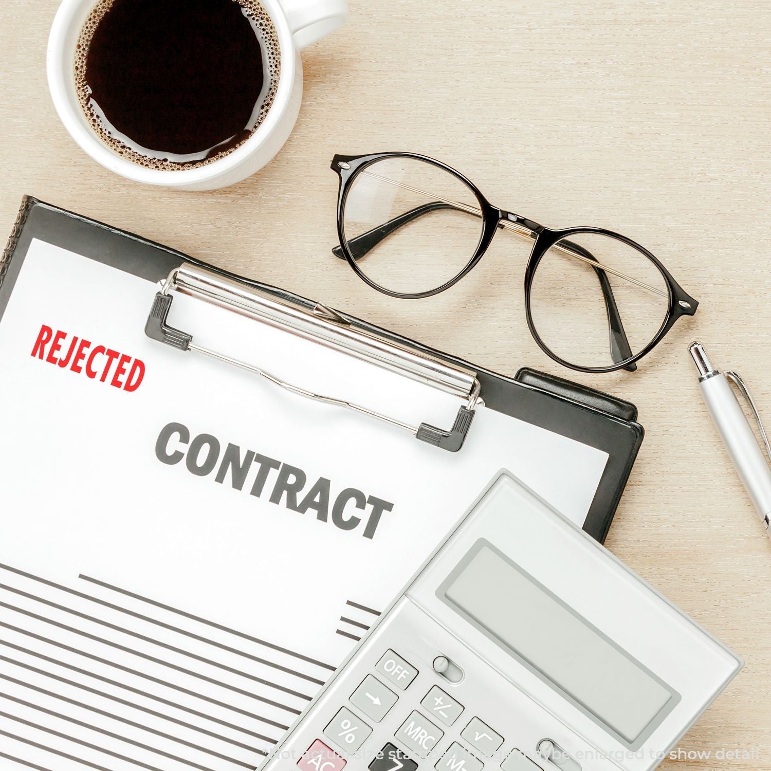 Rejected contract document on office desk with eyeglasses, coffee, calculator, and pen, business deal refusal concept