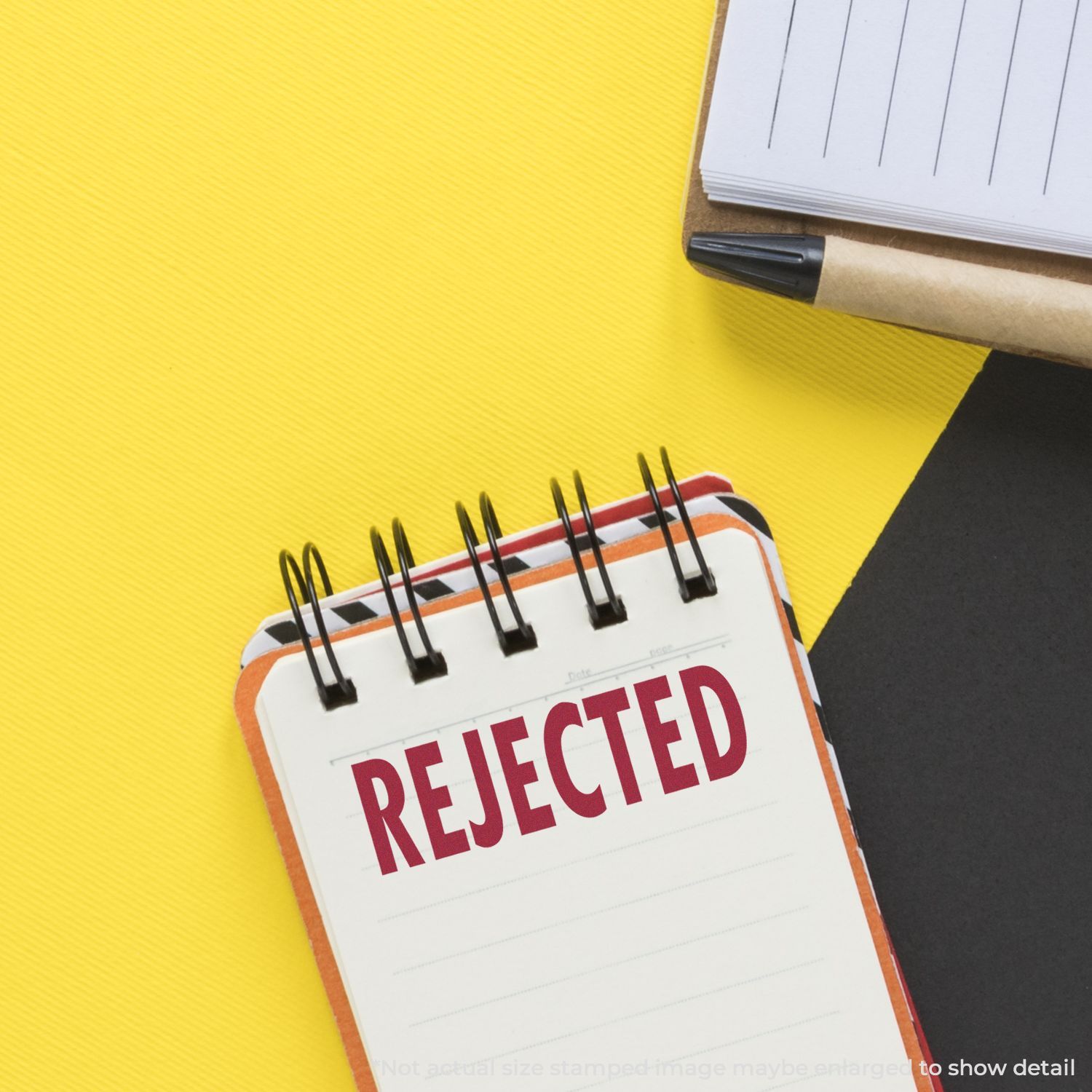 Rejected stamp on small notebook calendar, symbolizing rejection, denied applications, or unsuccessful outcomes for hiring and reviews.