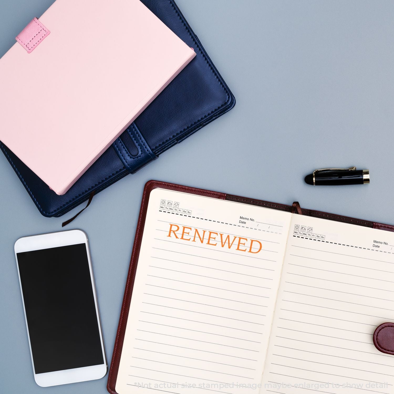 Top view of a renewed planner notebook with pen, phone, and leather covers on deskgoal setting and productivity concept.