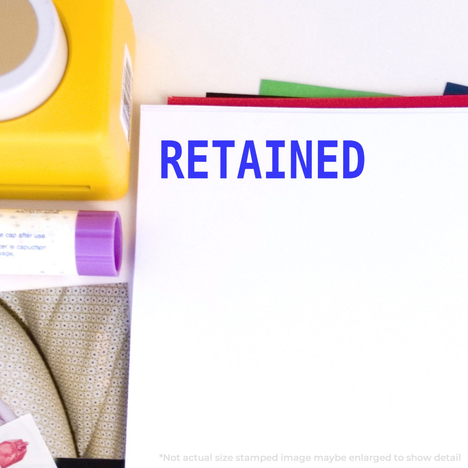 Close-up of a RETAINED stamp on paperwork with office supplies and documents, symbolizing record retention.