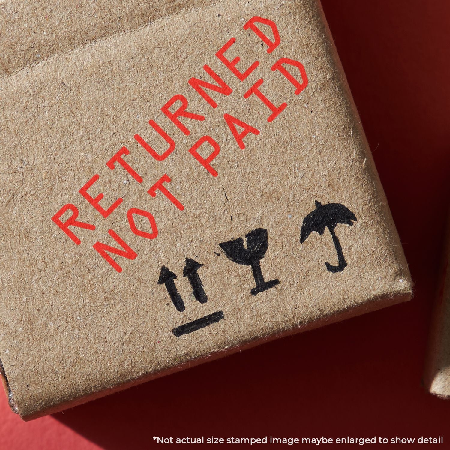 Returned not paid stamp on cardboard parcel, indicating a refused or unpaid shipping package.