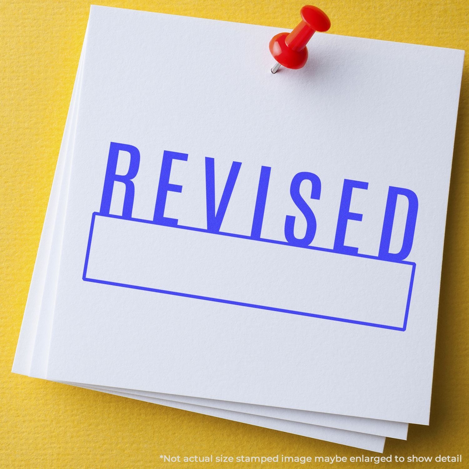 Red stamp marked 'REVISED' on a document with pushpin, indicating updated paperwork and editing status.
