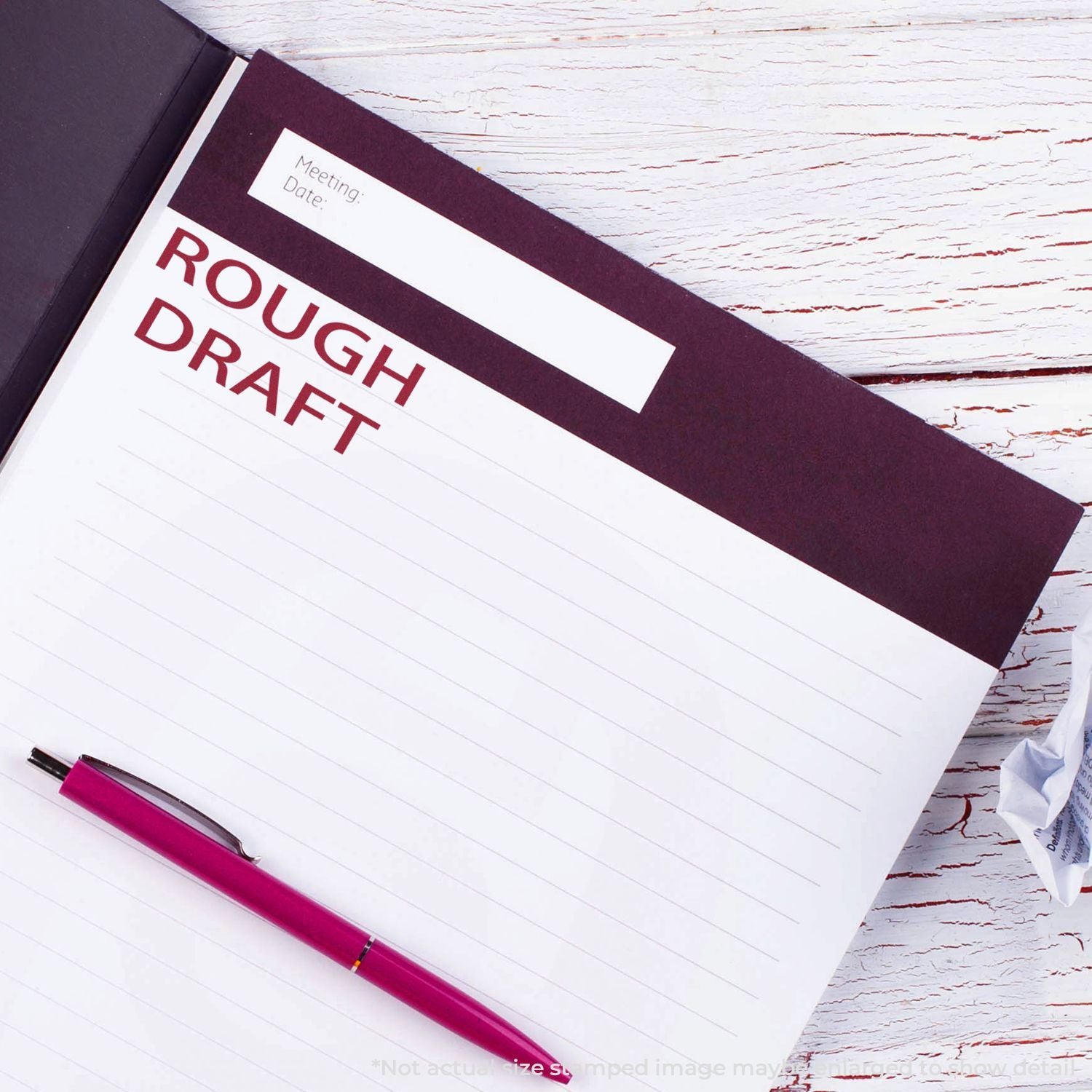 Rough draft notebook with pink pen on rustic white wooden desk, writing and planning concept.