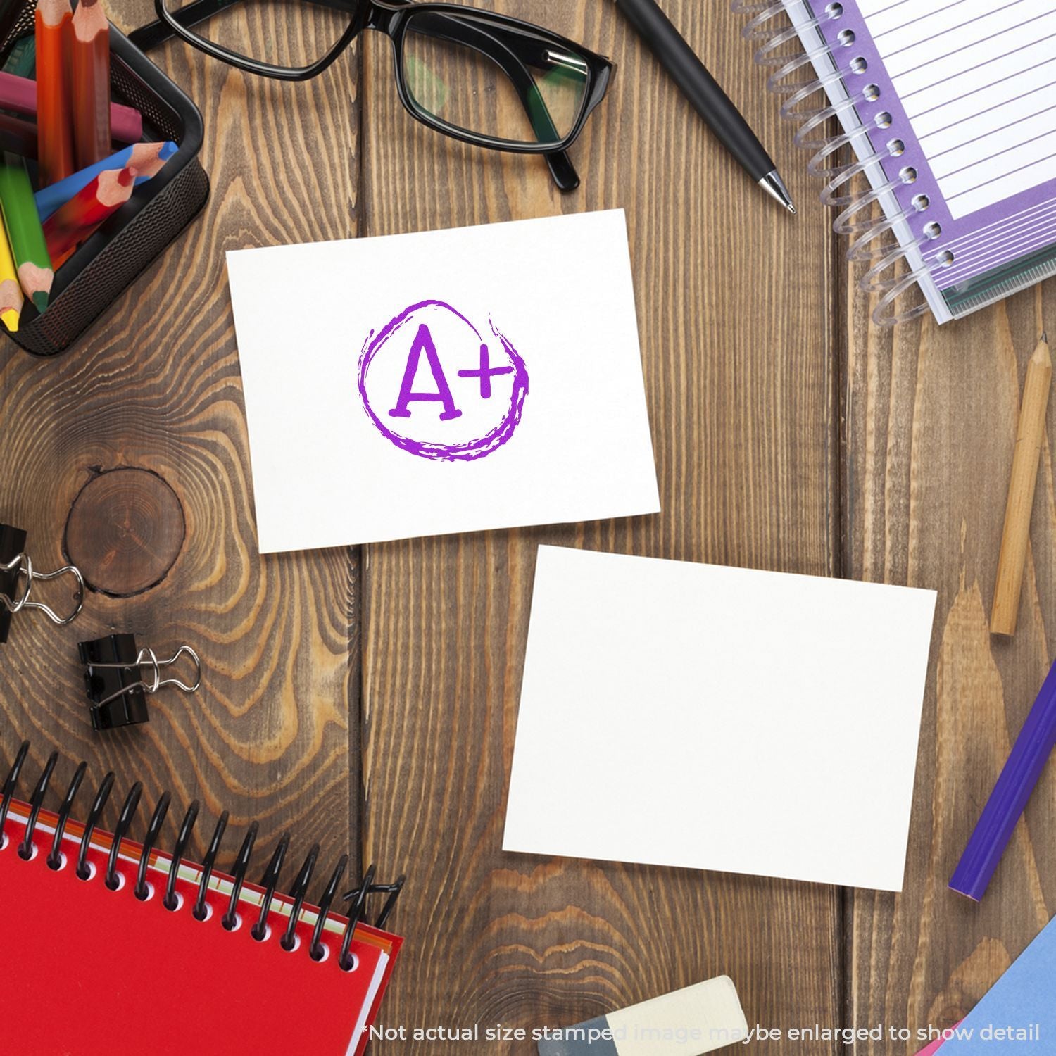 A+ grade on blank paper surrounded by school supplies on a wooden desk, education and academic success concept.
