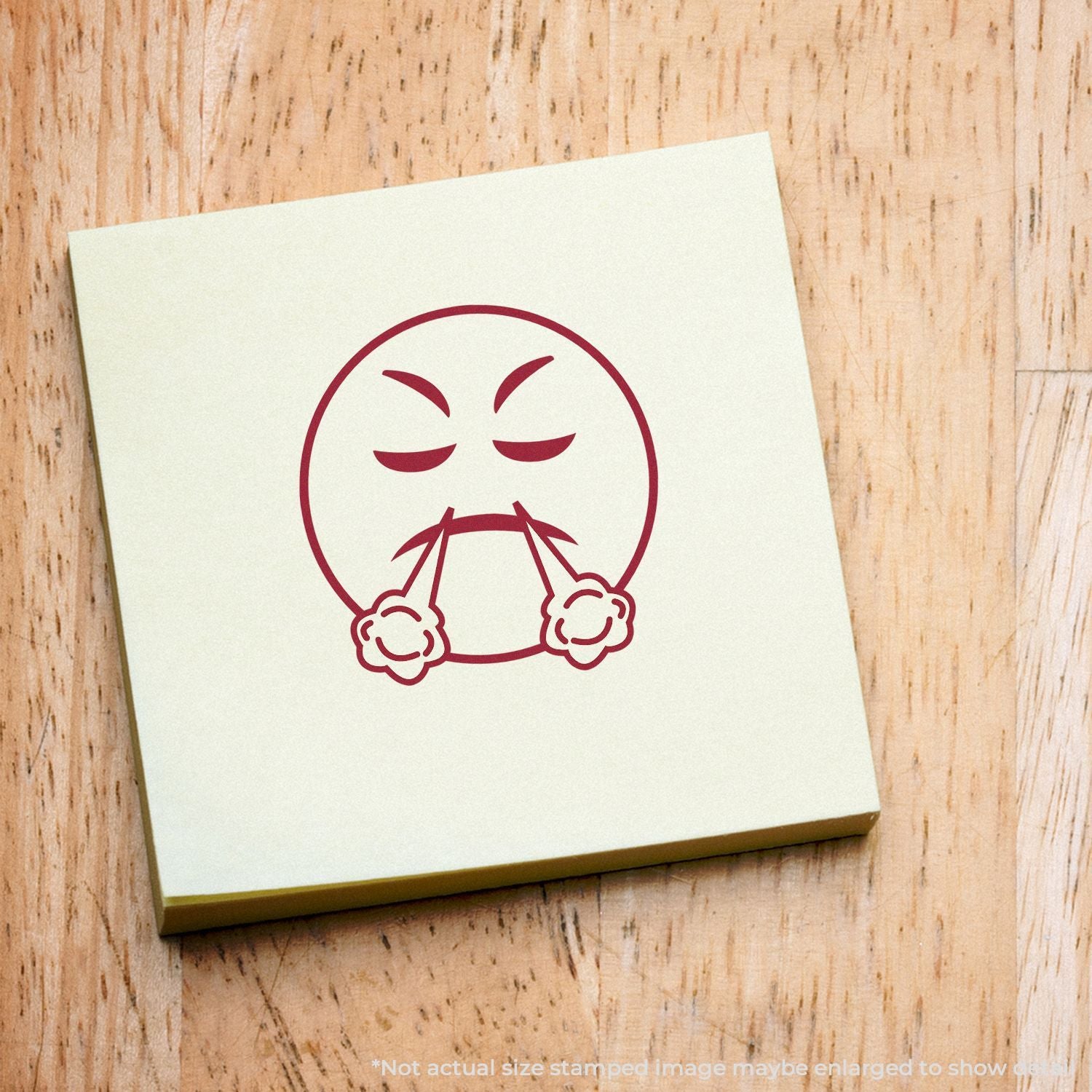 Angry emoji face stamp on a sticky note over a wooden background