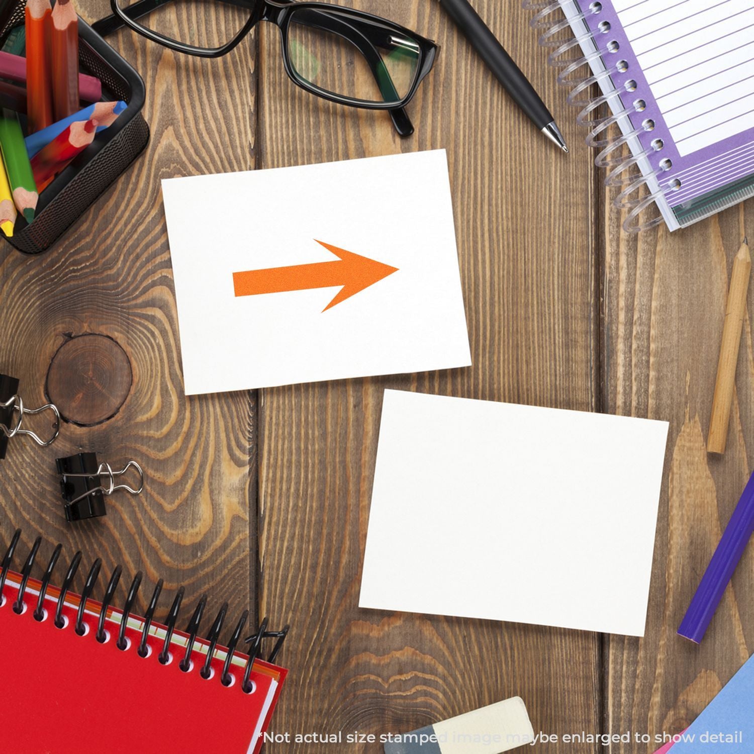 Office desk flat lay with blank note cards, orange arrow icon, pencils, glasses, and notebooks on a wooden background