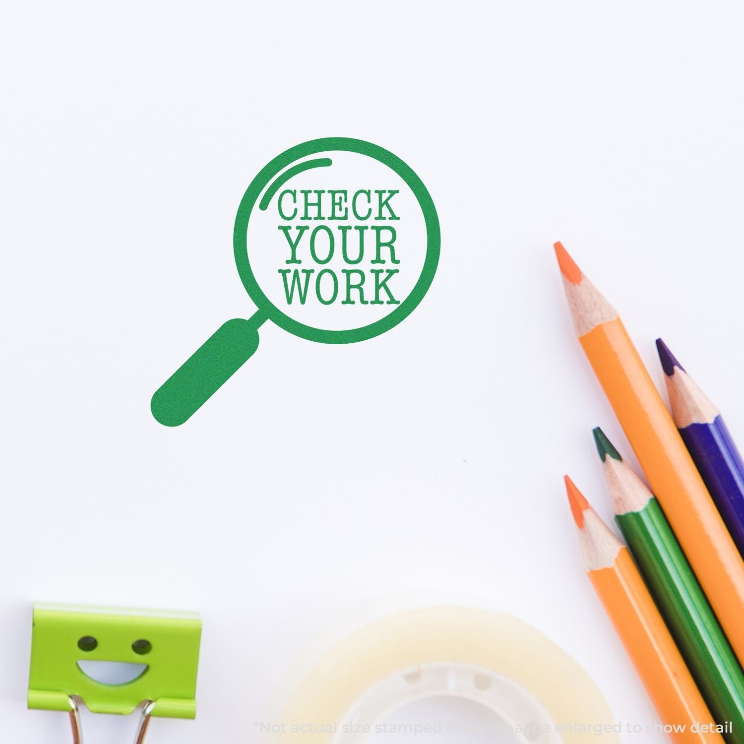 Green Check Your Work magnifying glass stamp with colorful pencils on white paper, school stationery proofreading concept.