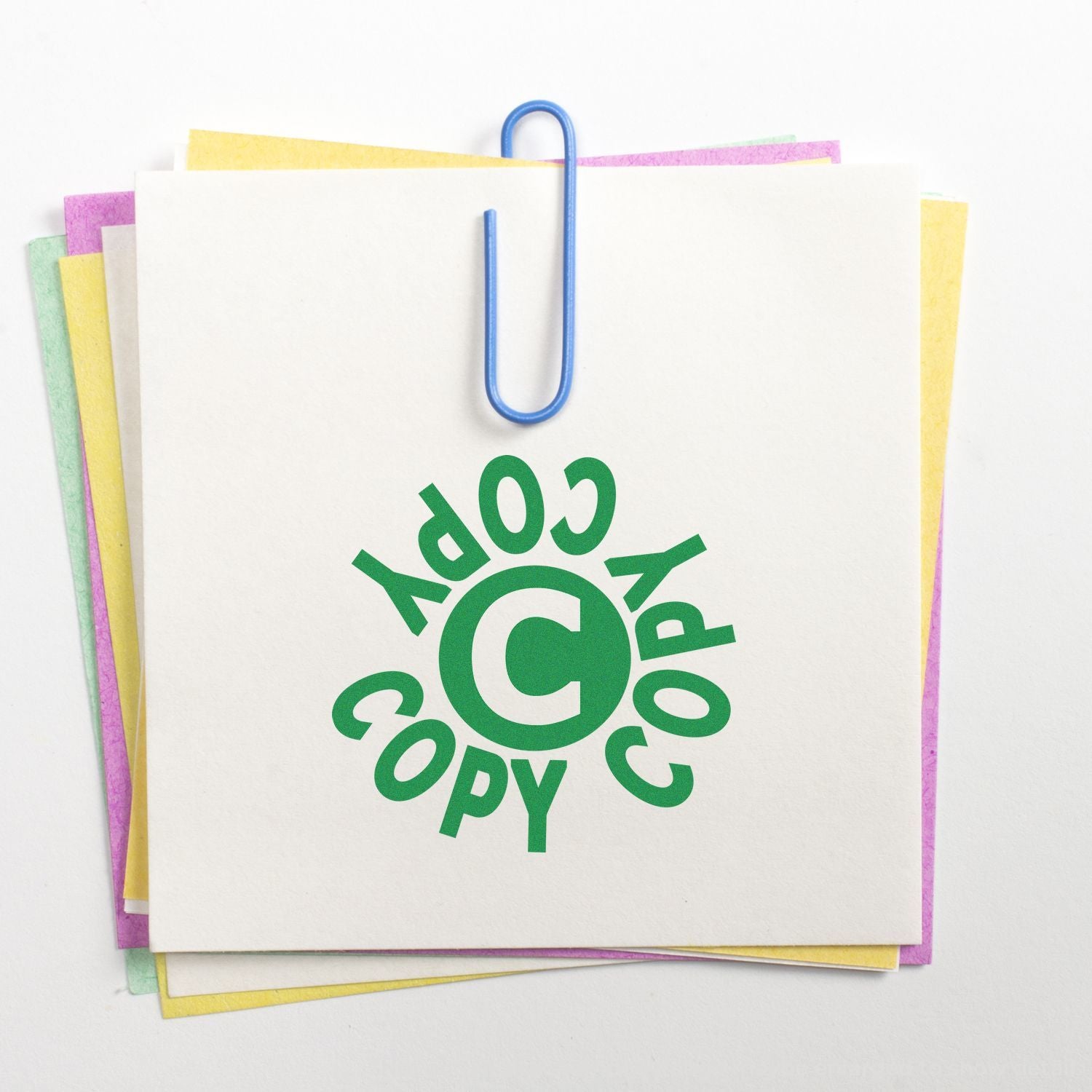 Stack of colorful papers clipped together with a green copyright symbol and copy text on white background