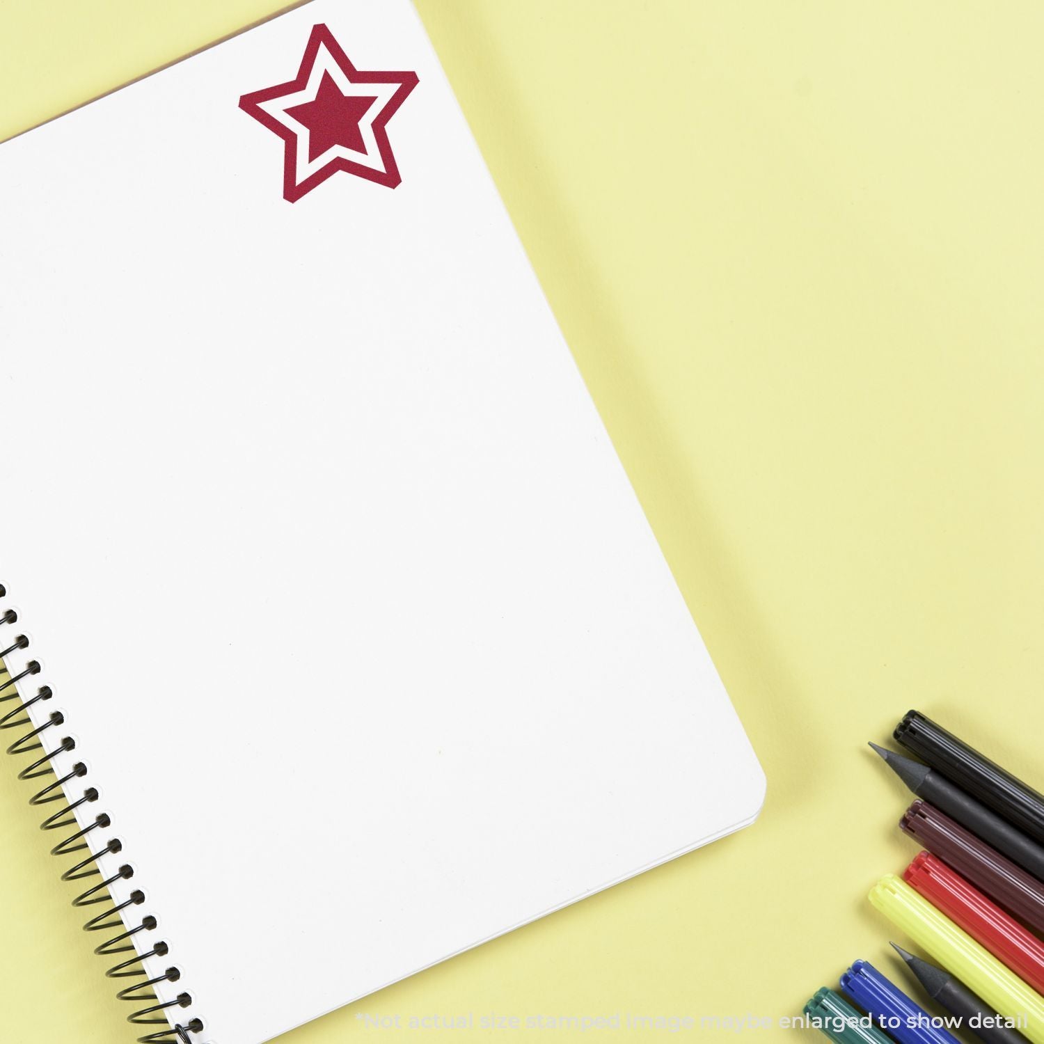 Blank spiral notebook with star sticker and colorful pens on yellow background, stationery flat lay concept