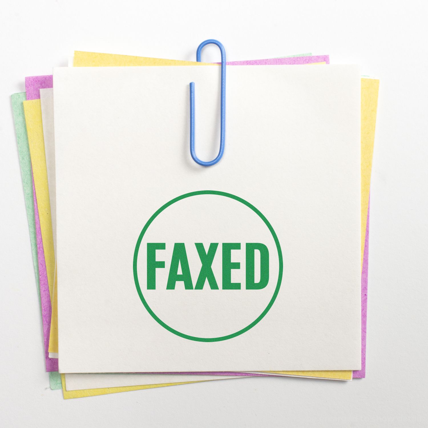Stack of colorful documents clipped together with a blue paperclip, featuring a green FAXED stamp on white paper.