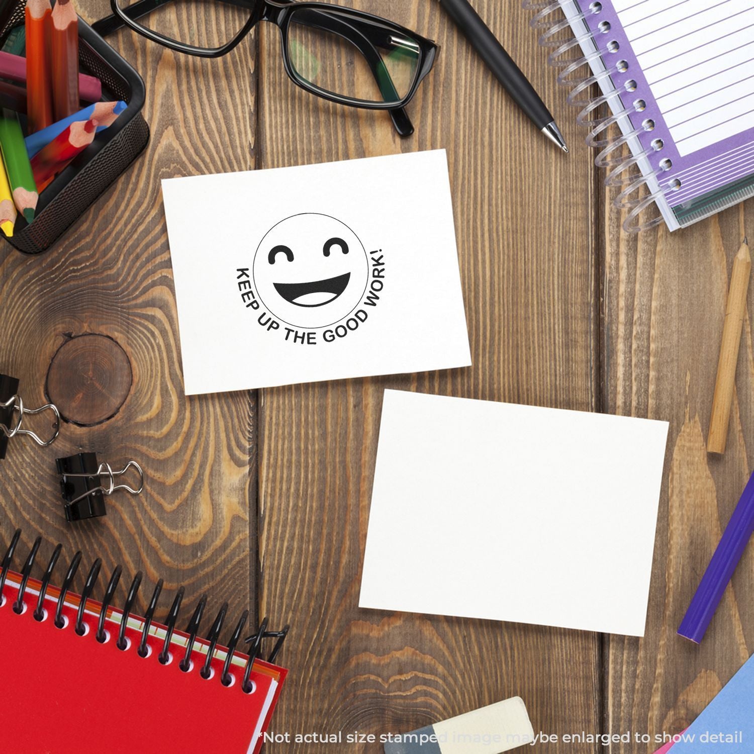 Desk workspace with stationery, notebooks, glasses, and a Keep Up the Good Work smiley note on a wooden table