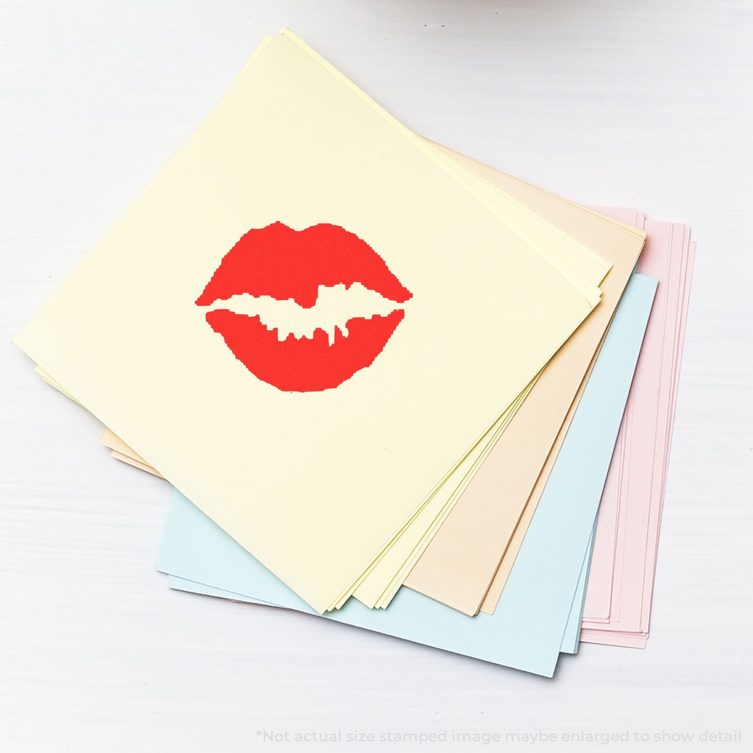 Stack of pastel greeting cards with red kiss lips stamp on top, blank stationery set