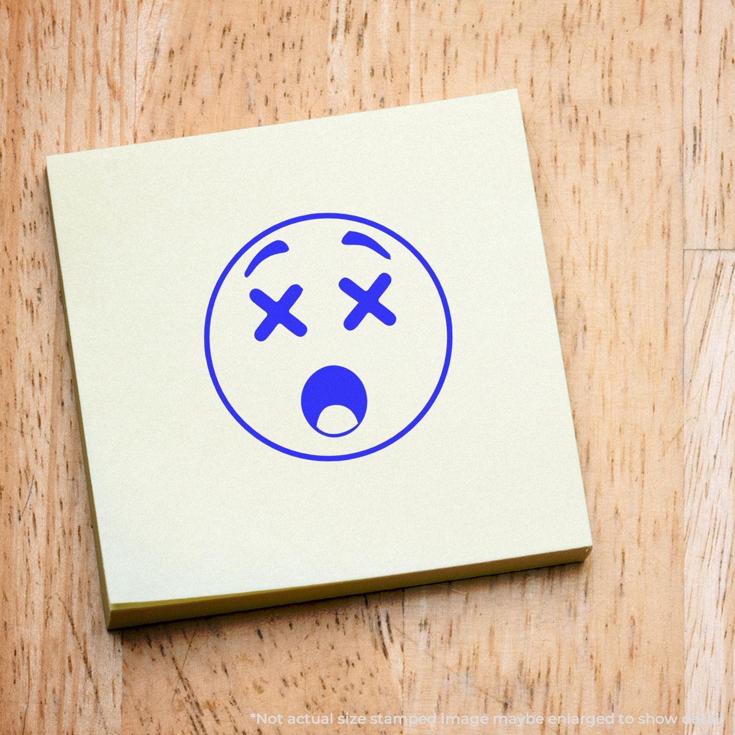 Blue dizzy face emoji sticker on a sticky note over a wooden background