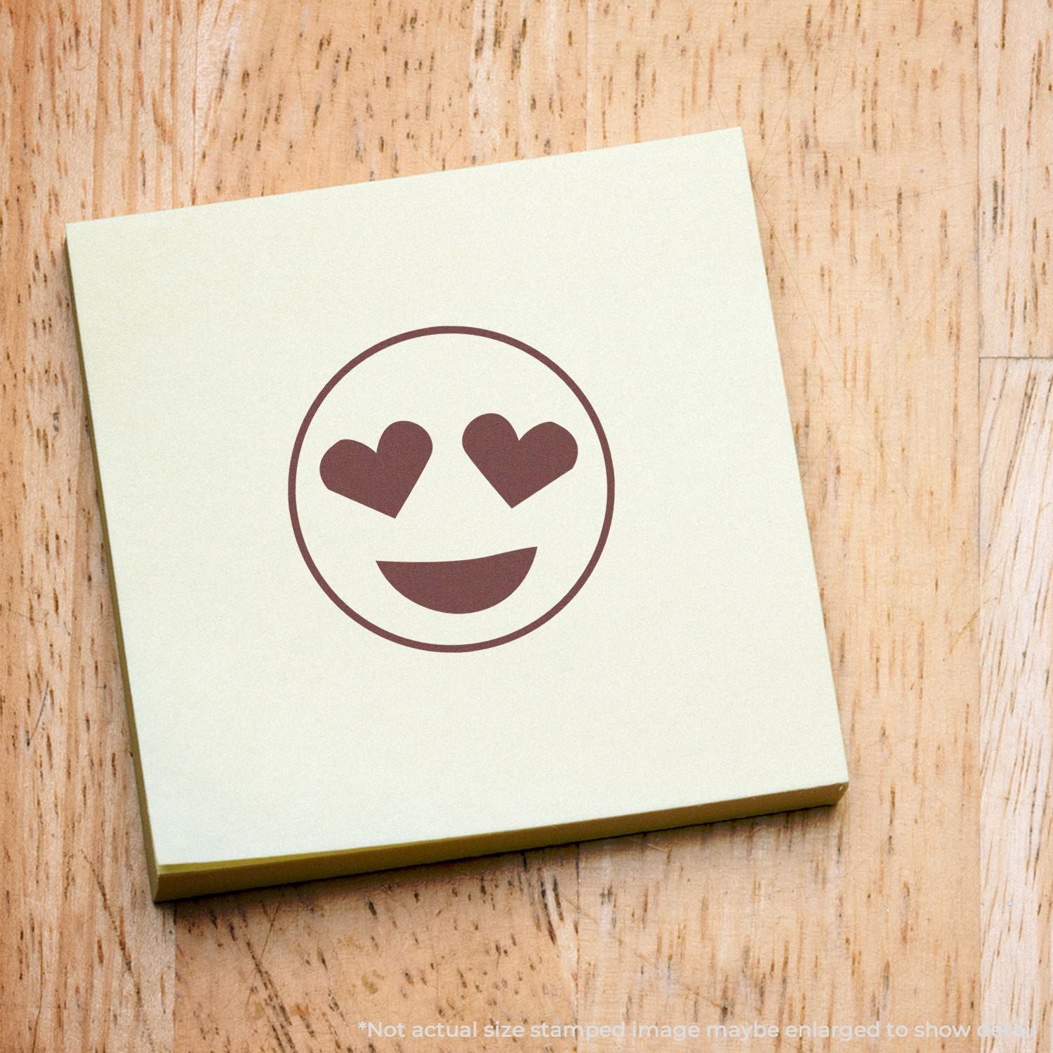 Heart eyes smiley sticky note on a wooden table, cute love-themed emoji design.