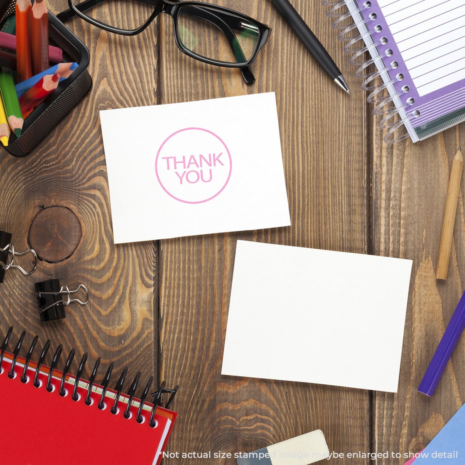 Thank you card mockup on wooden desk with stationery, notebooks, pens, and glasses.