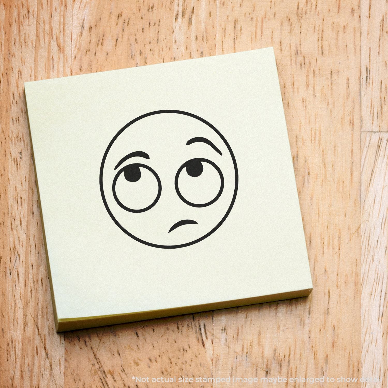 Confused face emoji on a sticky note on a wooden background.