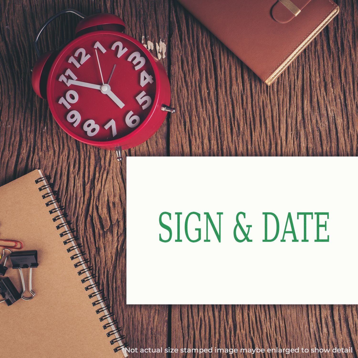 Red alarm clock and planner on wooden desk with Sign & Date message, indicating document signing deadlines and productivity.