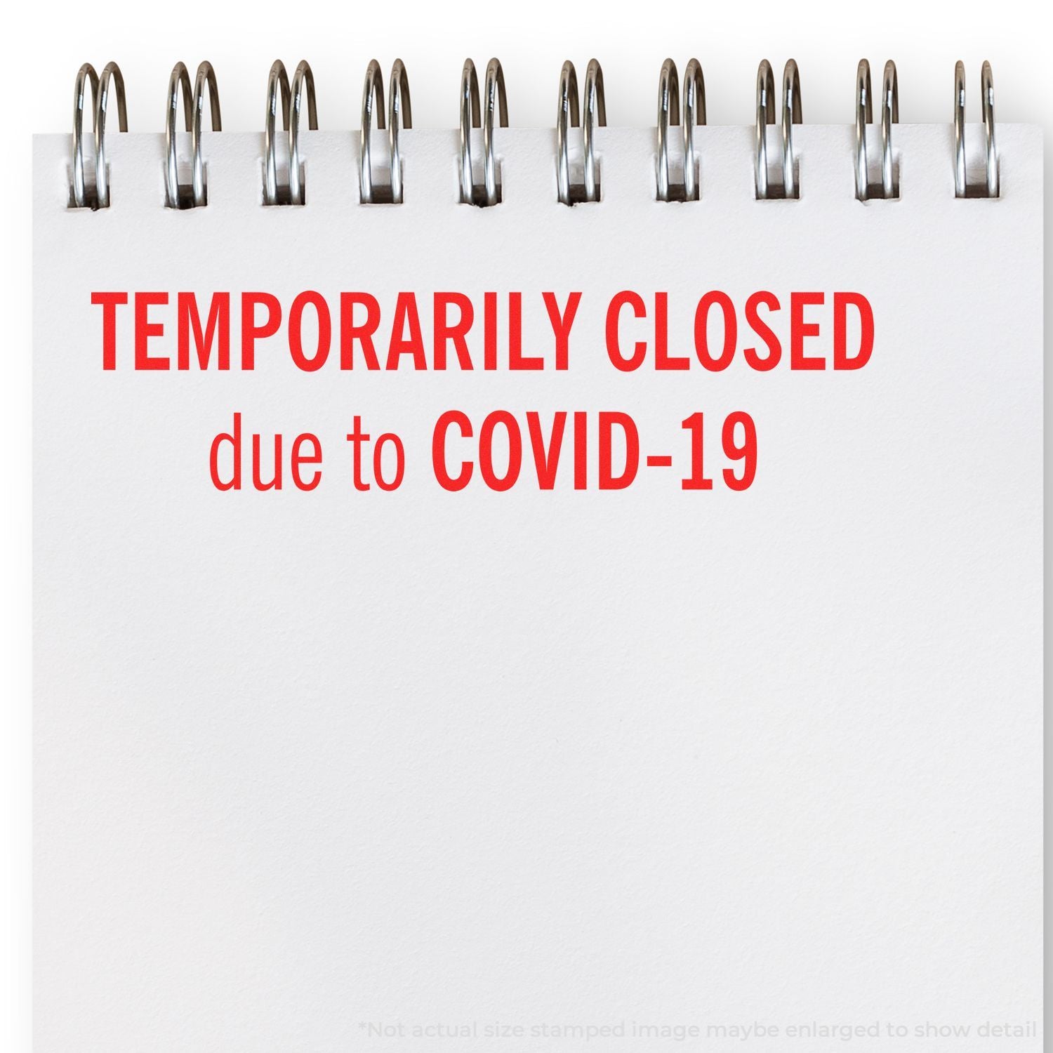 Spiral notebook with Temporarily Closed due to COVID-19 sign on white background.