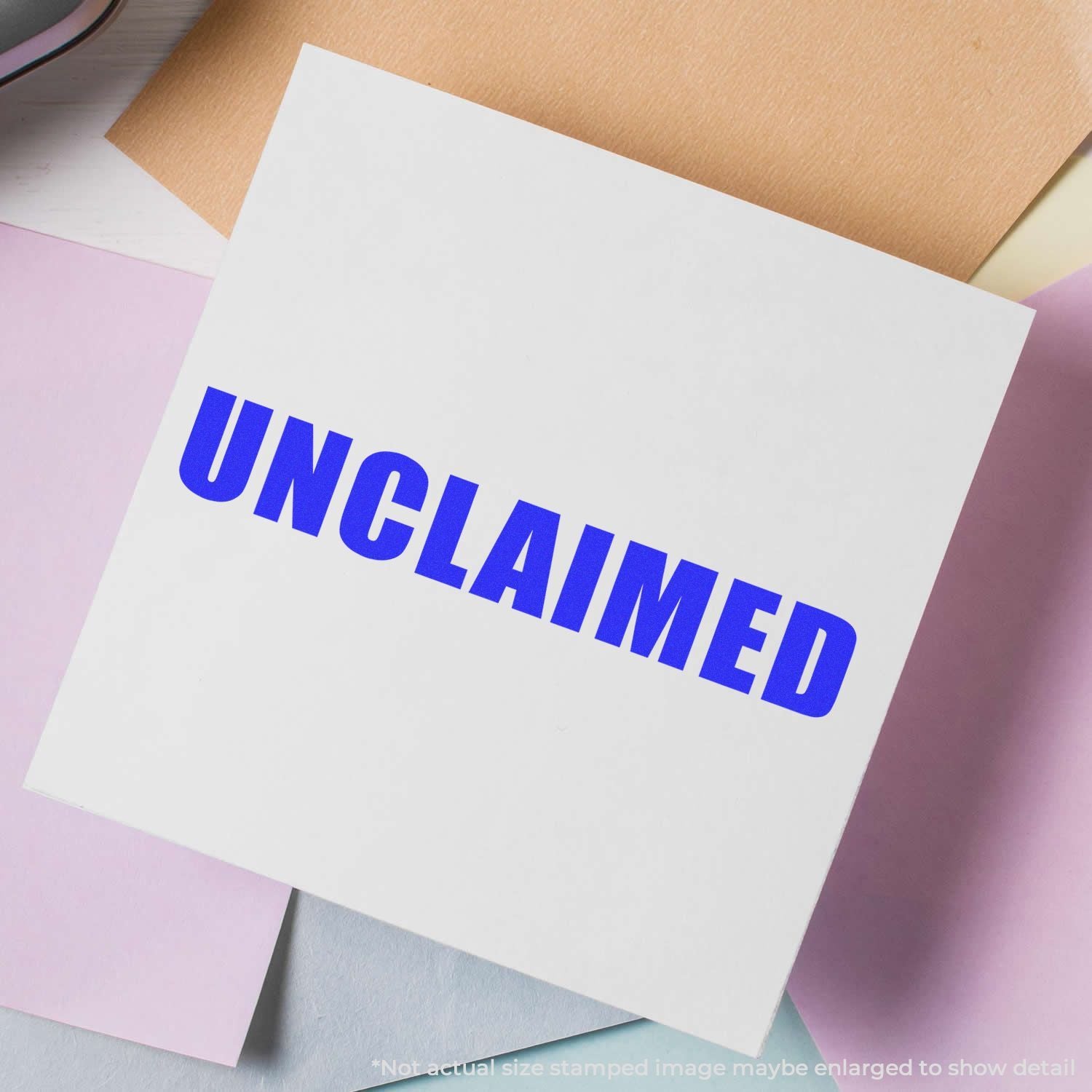 White paper card with bold blue UNCLAIMED stamp on a pastel paper background