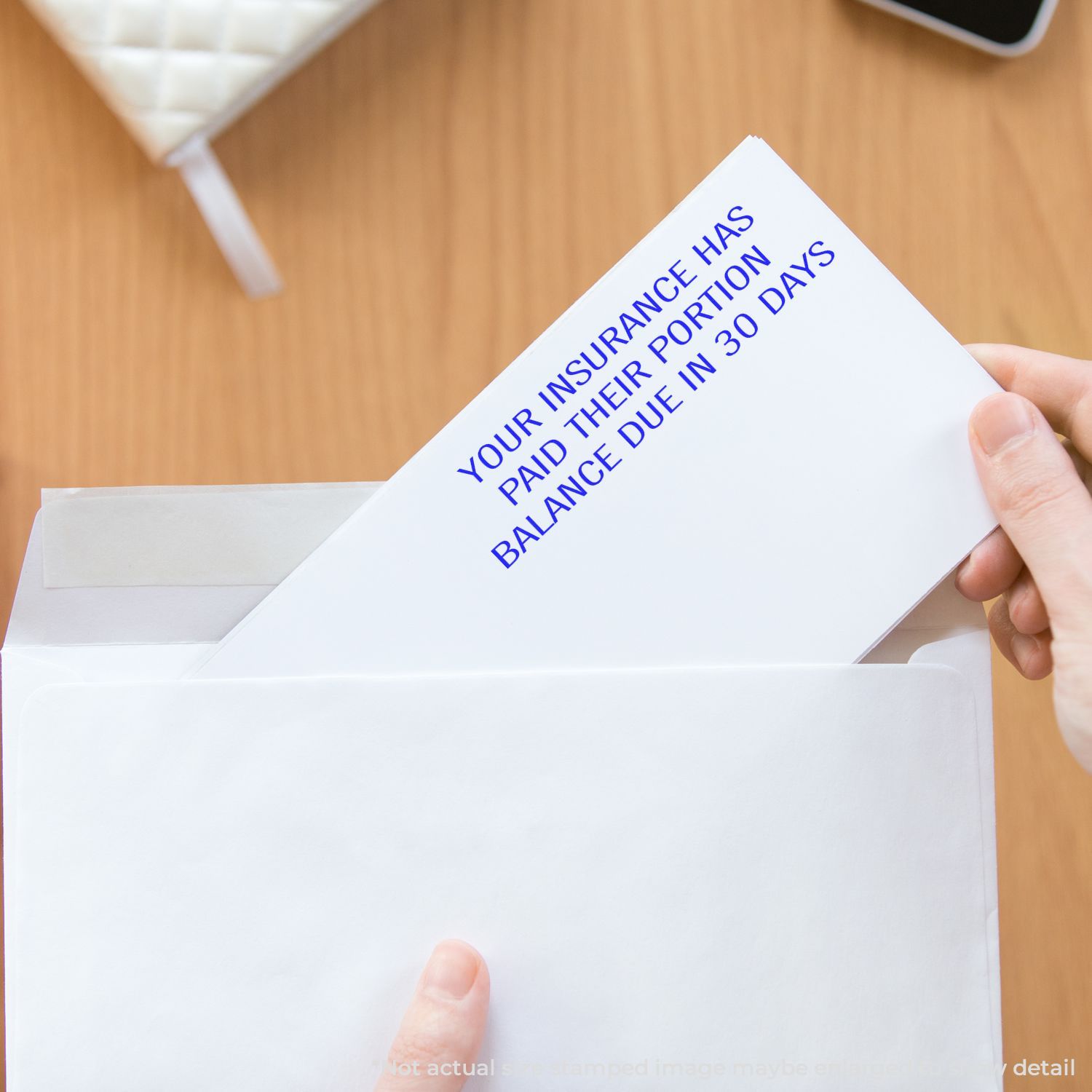 Hand opening an insurance notice letter stating the premium balance is due in 30 days.