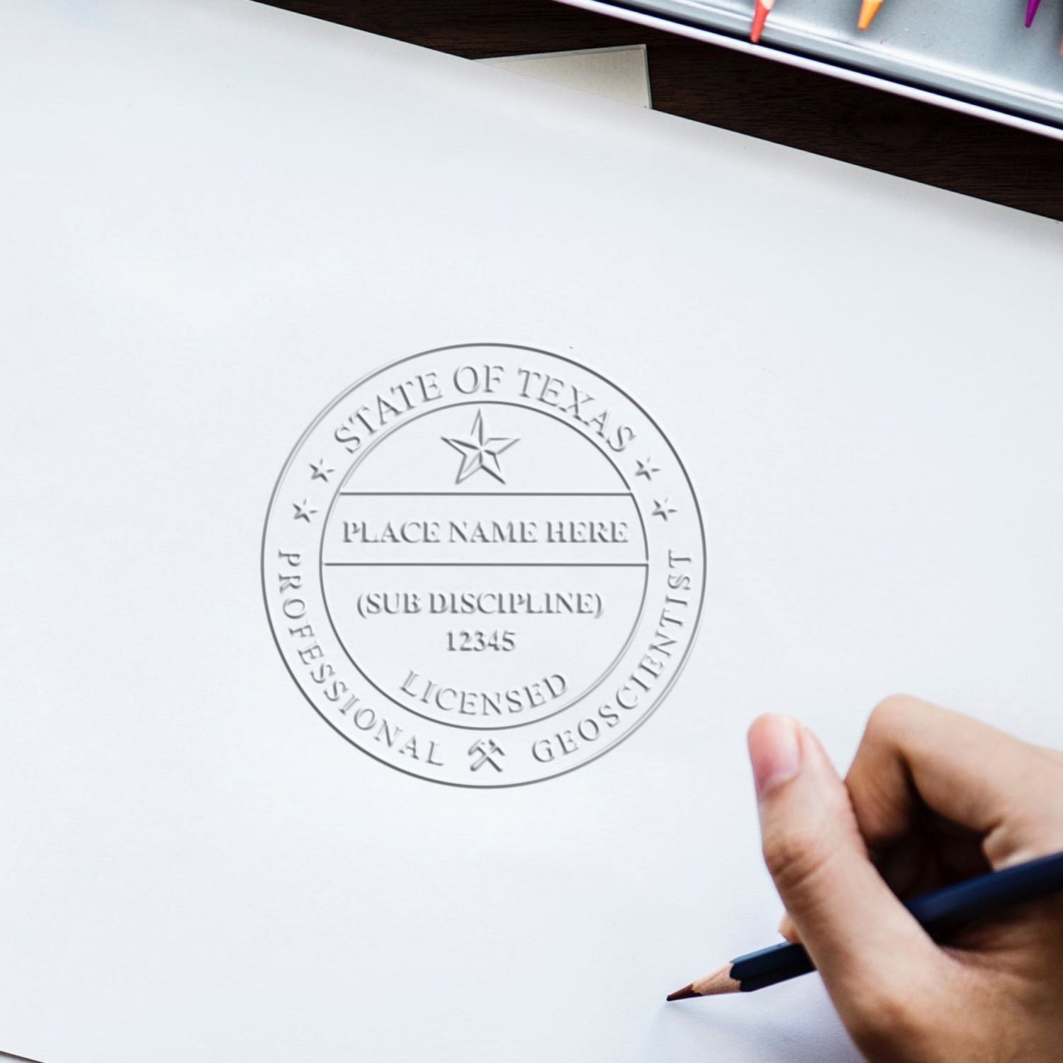 Hand holding pencil over State of Texas Professional Geoscientist licensed seal on blank document template
