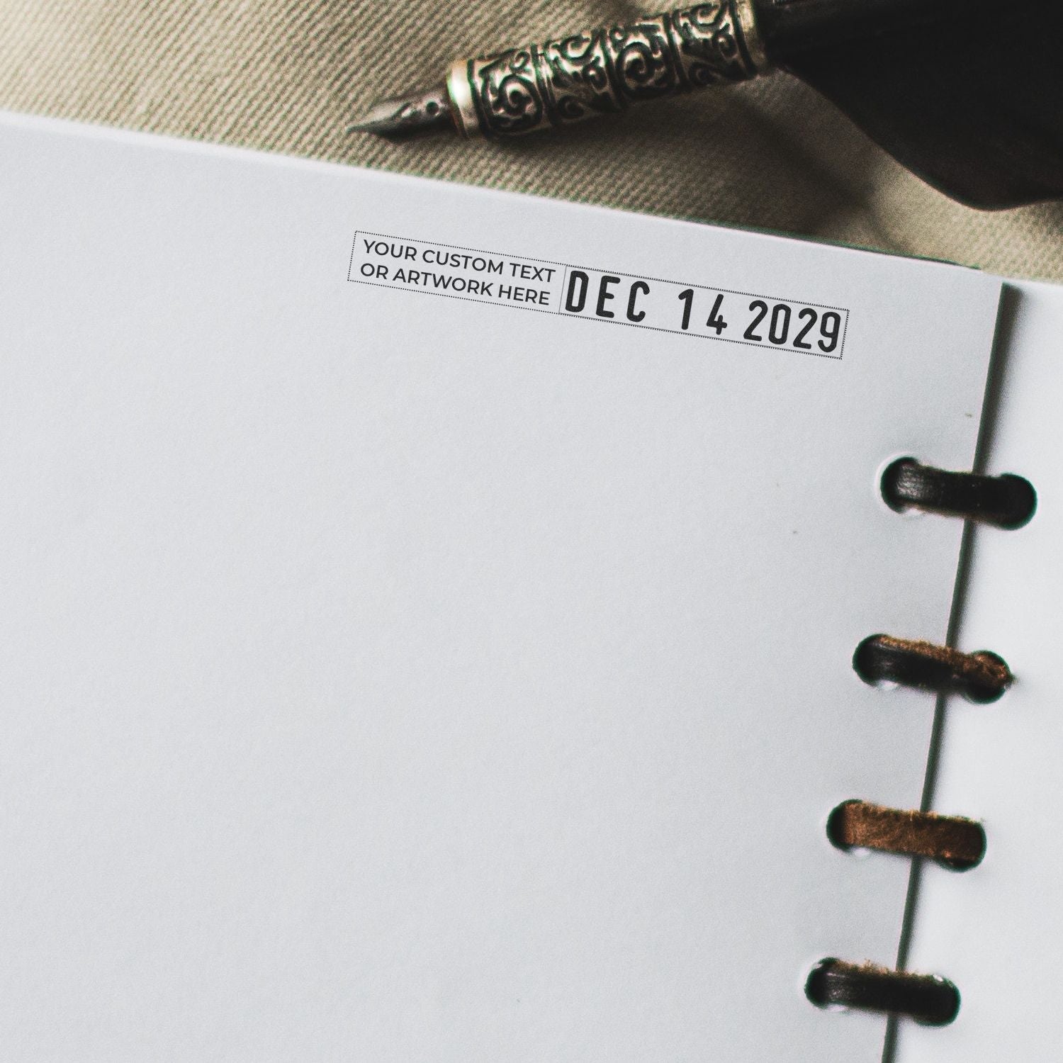 Close-up of a custom planner page with date stamp Dec 14 2029 and pen, featuring blank notebook space and disc binding.