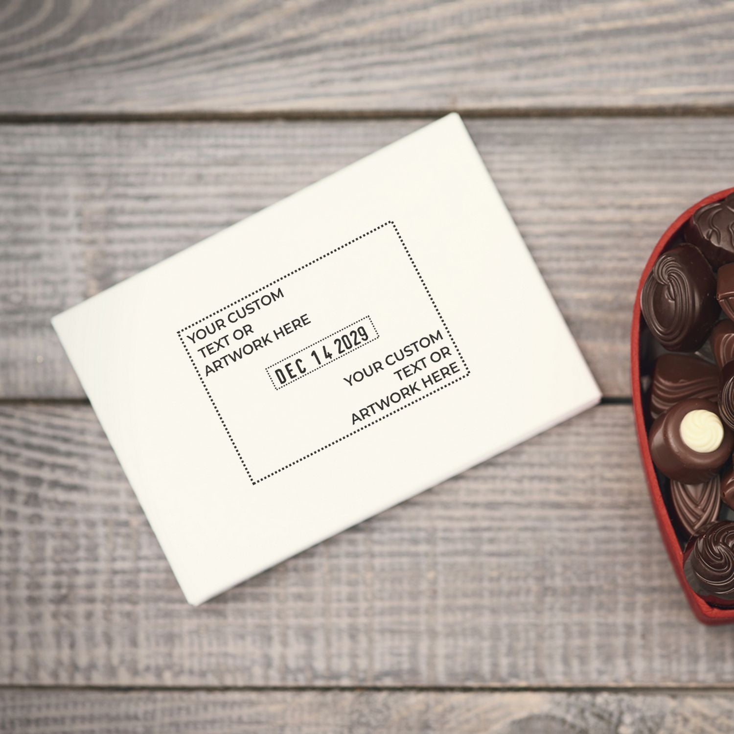 Personalized chocolate gift box with custom text and date on rustic wooden background, featuring assorted heart-shaped chocolates.