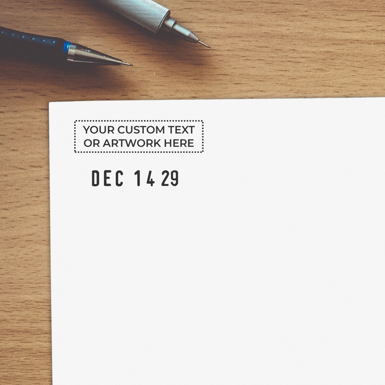 Custom text and artwork mockup on white paper with pens on a wooden desk, personalized stationery template design.