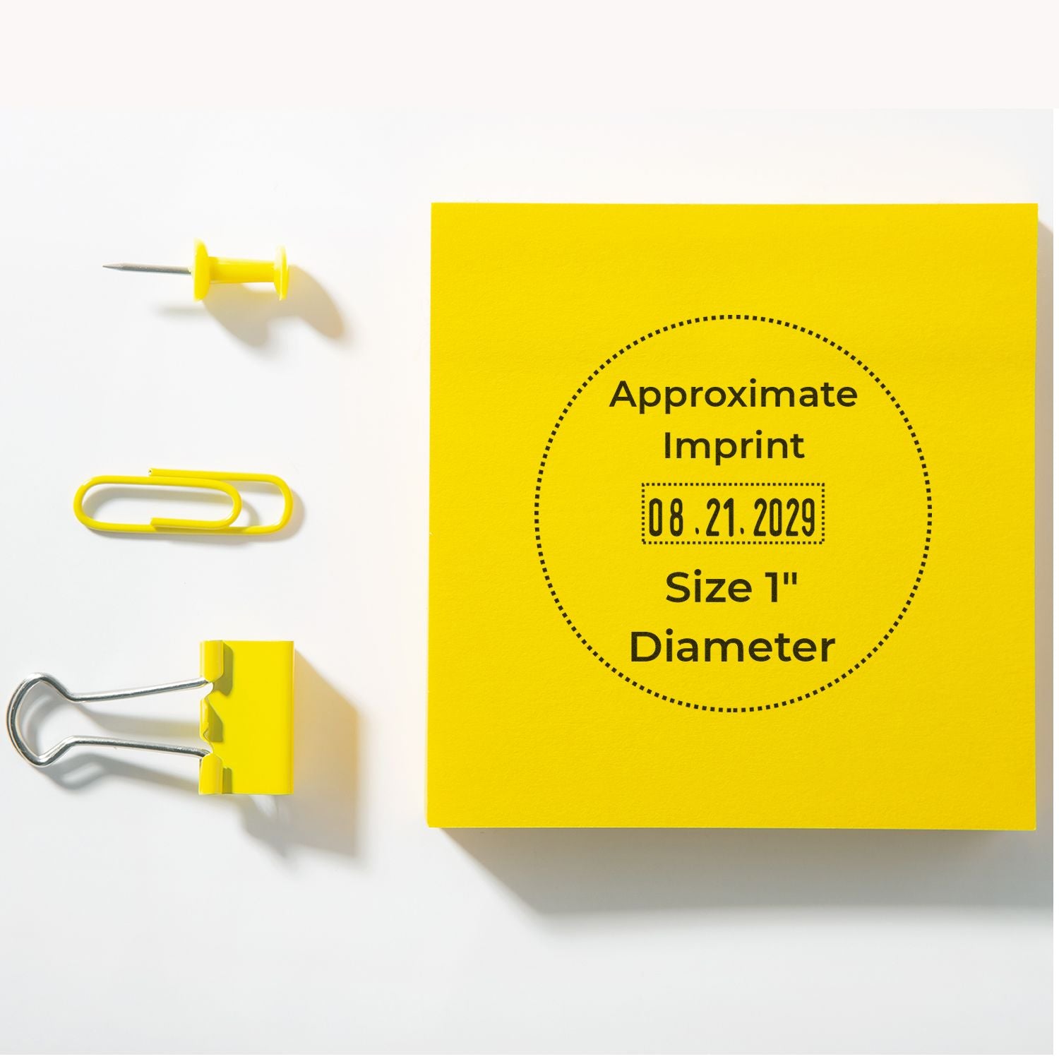 Yellow office stationery flat lay with push pin, paperclip, binder clip, and sticky note showing Approximate Imprint date stamp.