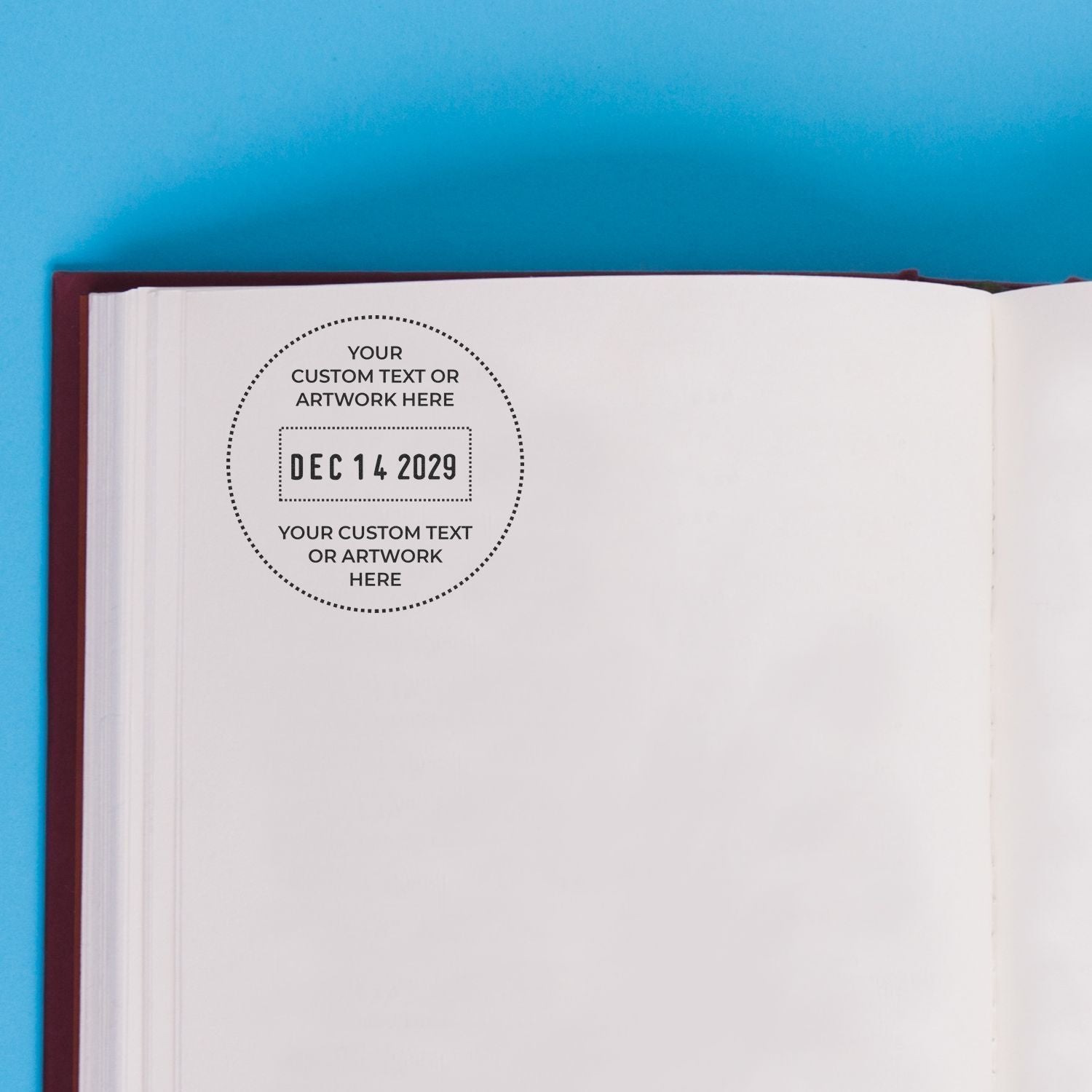 Open book page with custom date stamp template and blank personalized artwork space on blue background.