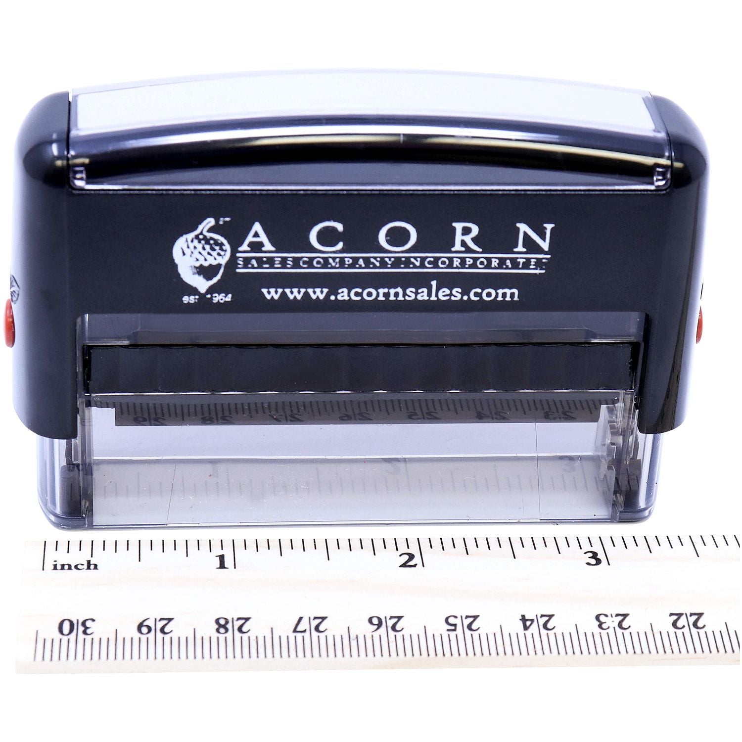 Acorn self-inking stamp with clear handle and measurement ruler on white background.