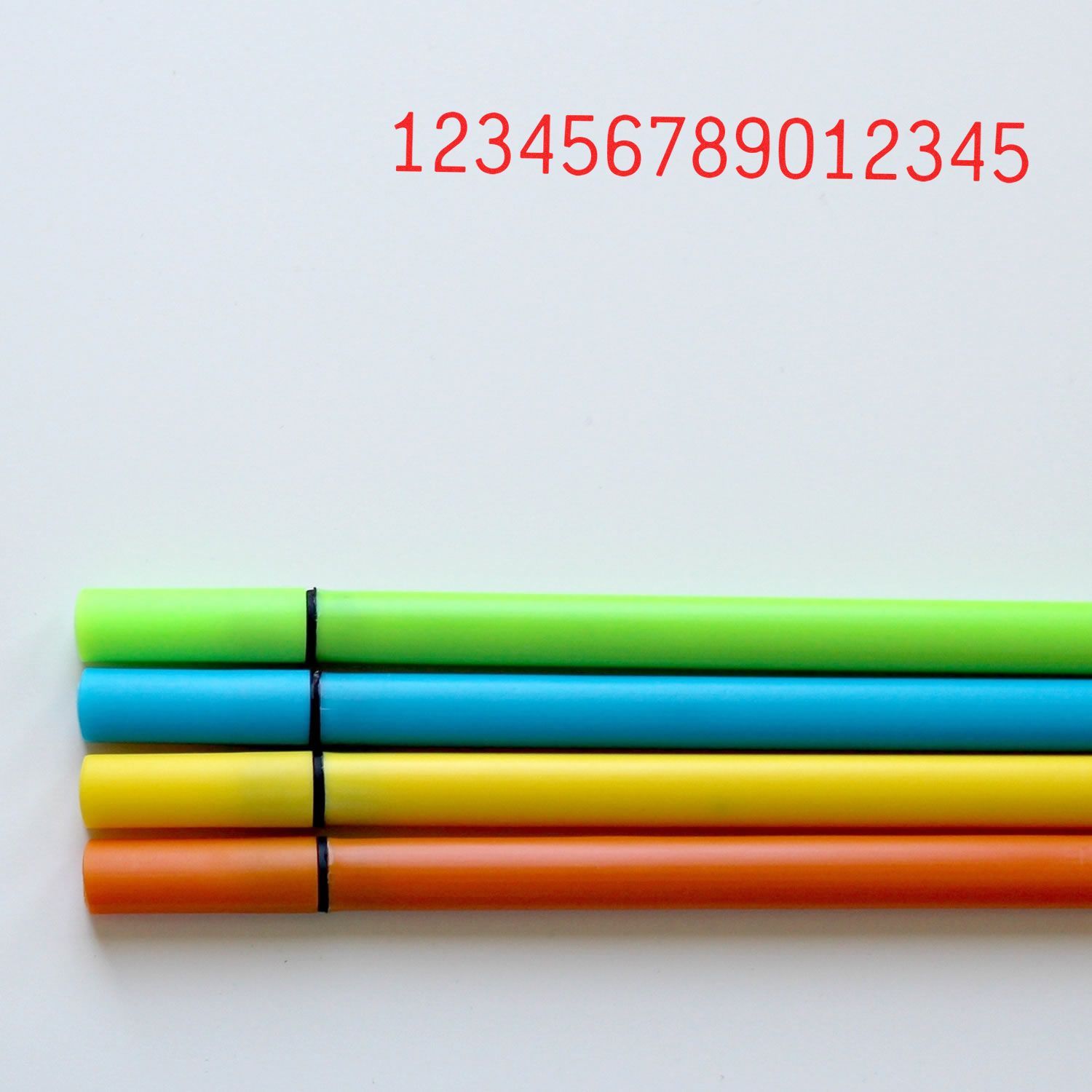 Four colorful marker pens on a white background with red numbers above, close-up stationery image
