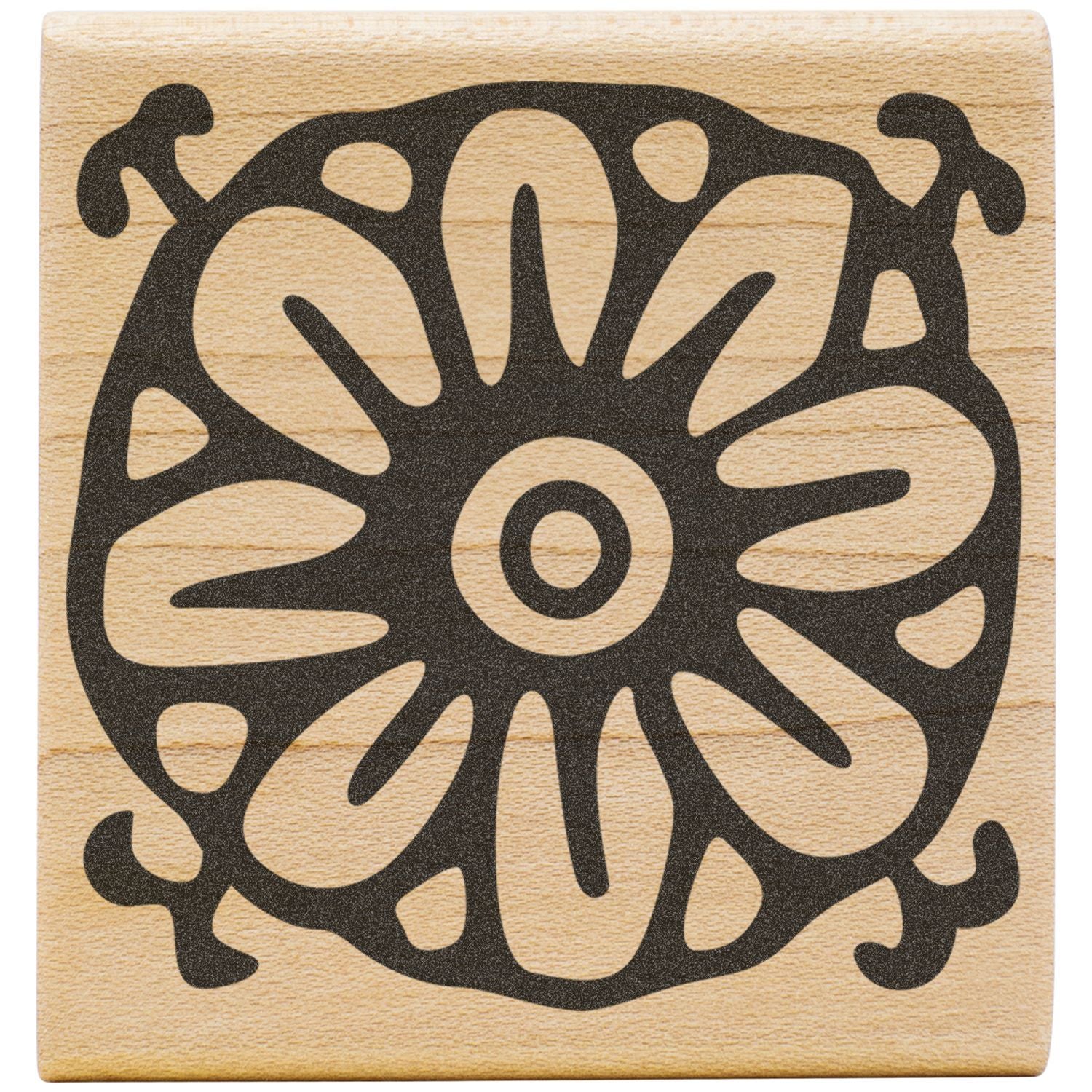 Ornate black floral mandala design engraved on a light wooden block.