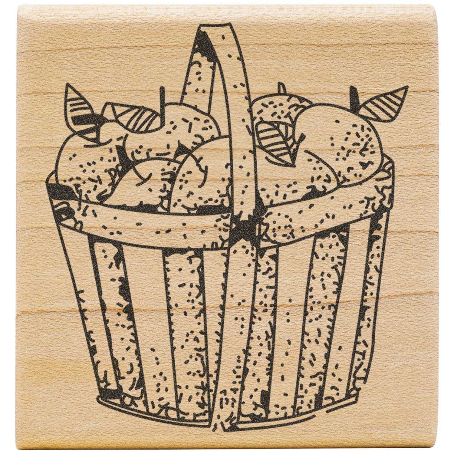 Rustic wooden stamp with an engraved basket of apples and leaves on a natural wood background.