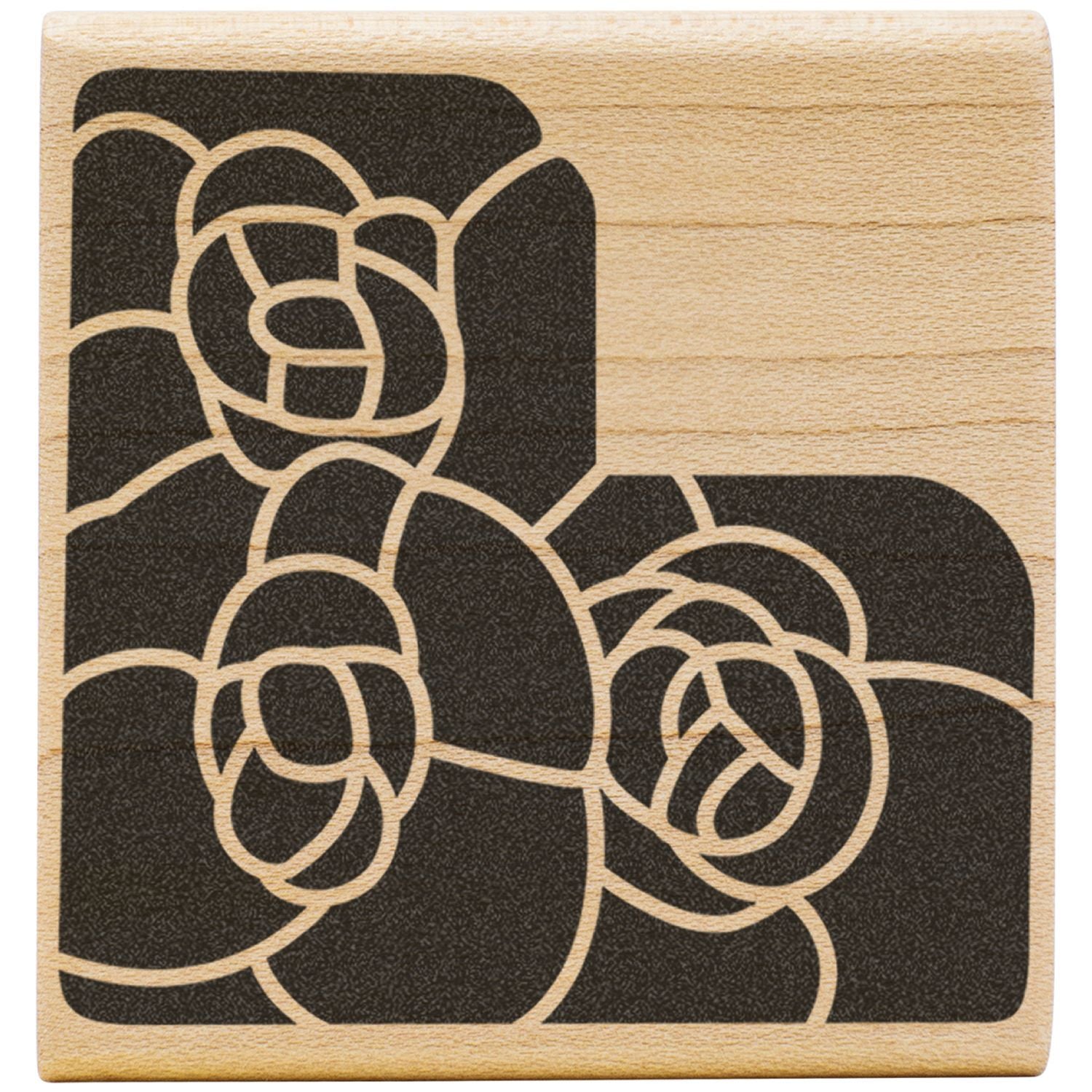 Abstract floral pattern on a wooden stamp block with black decorative design.