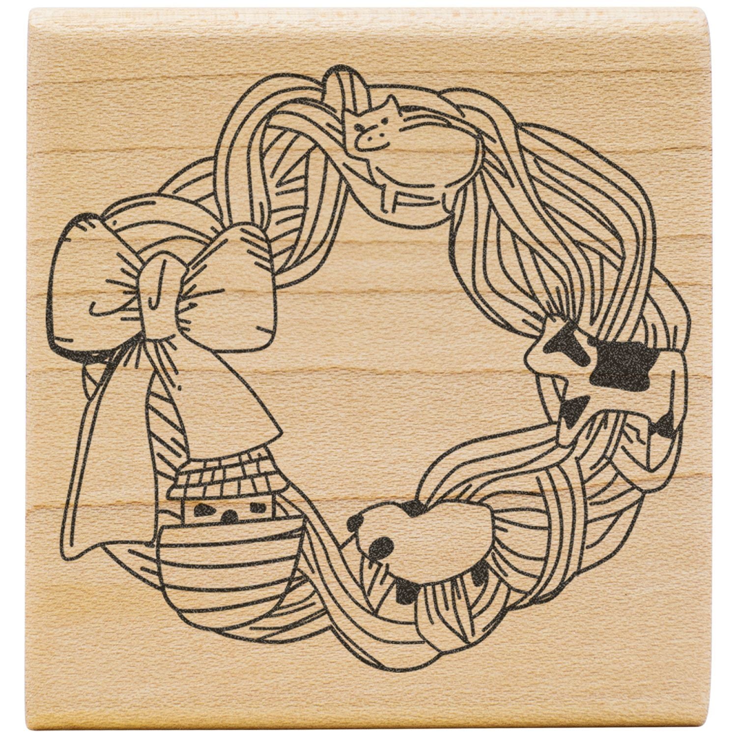 Wooden stamp with cute cats forming a circular wreath design on a natural wood background.