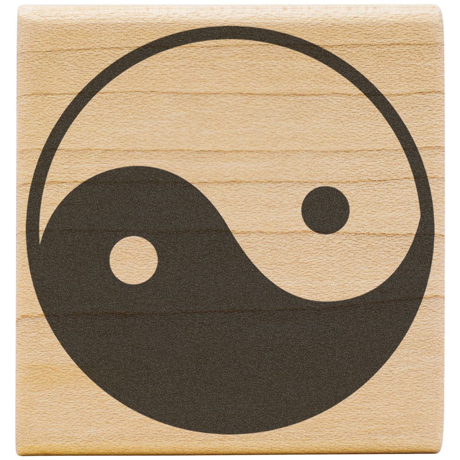 Yin yang symbol engraved on a wooden tile, representing balance and harmony.