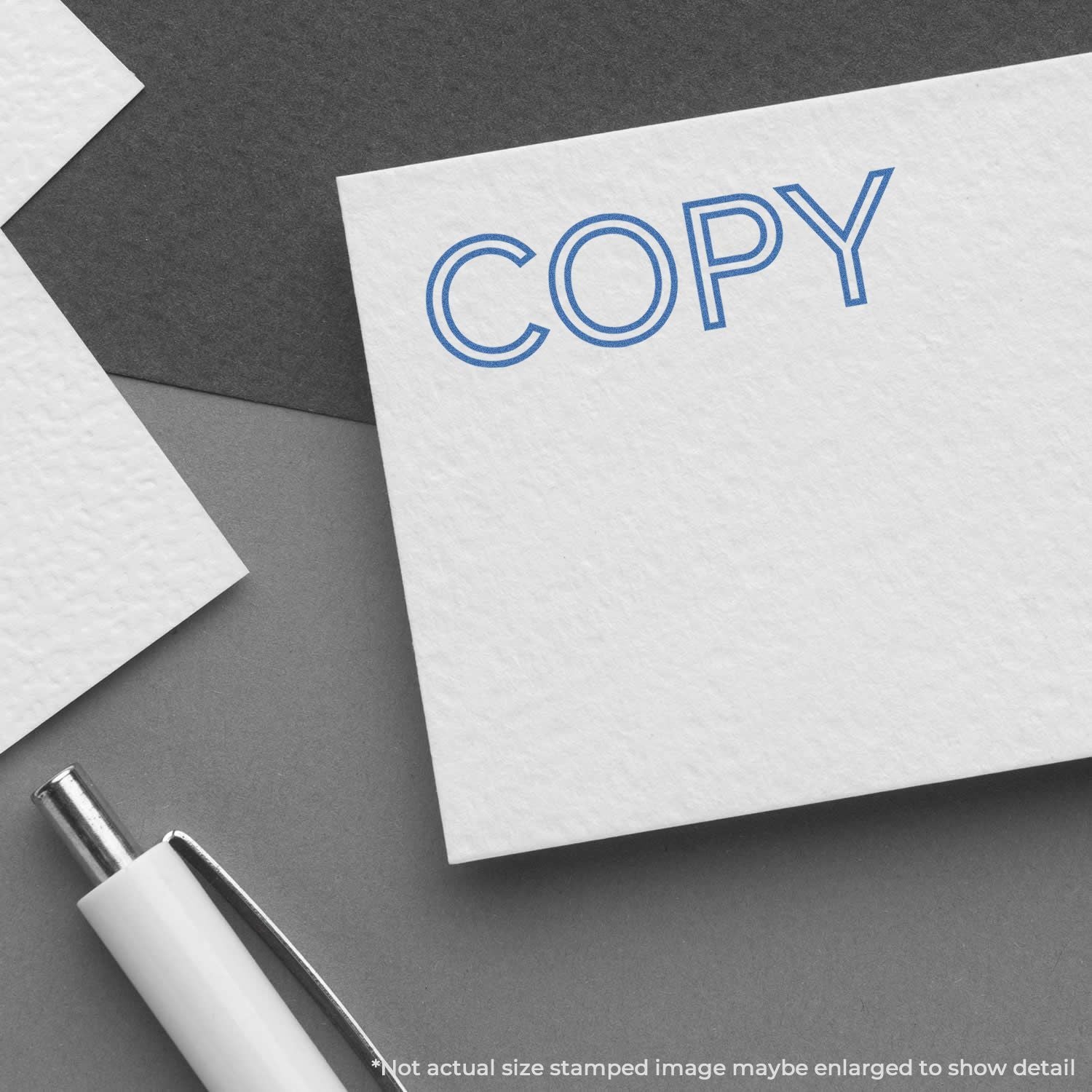 White paper with blue COPY headline on a gray desk, illustrating professional printing and copy design branding concept.
