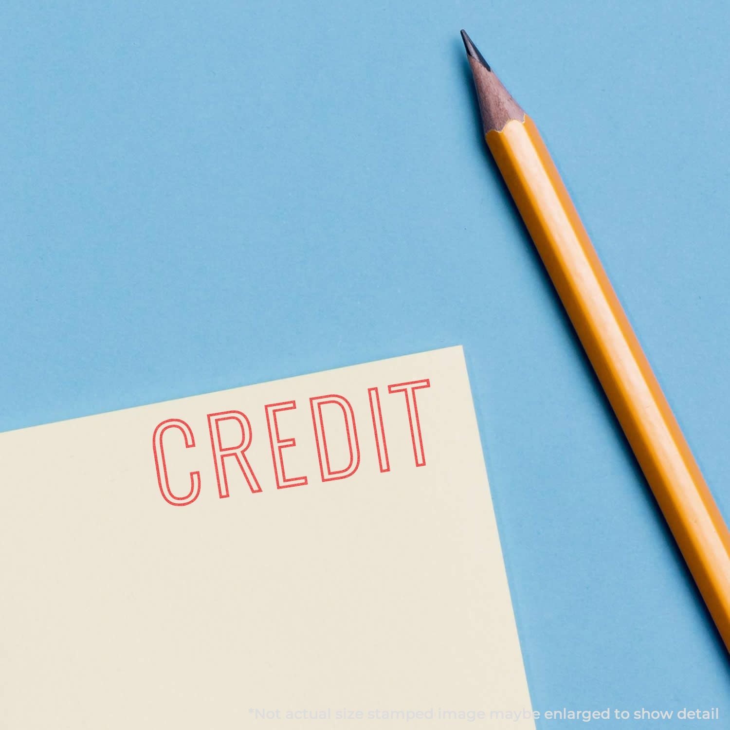 Credit concept: pencil and note card reading CREDIT, symbolizing personal finance, credit score, and budgeting on blue background.