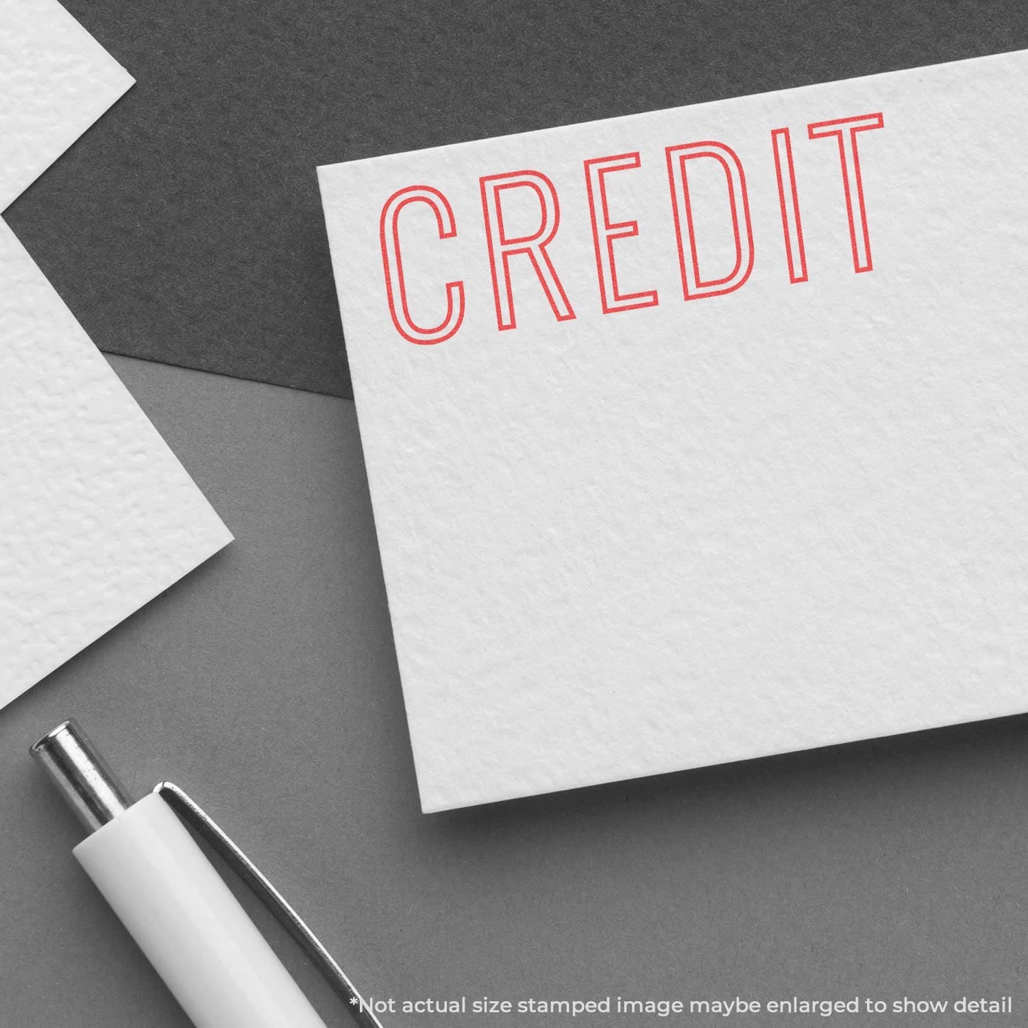 Red stamped word CREDIT on white stationery with pen, representing credit and financial services marketing.