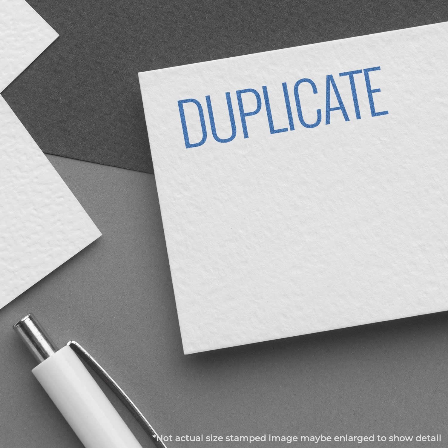 Duplicate document stamp concept: DUPLICATE printed on white form with pen on office desk.