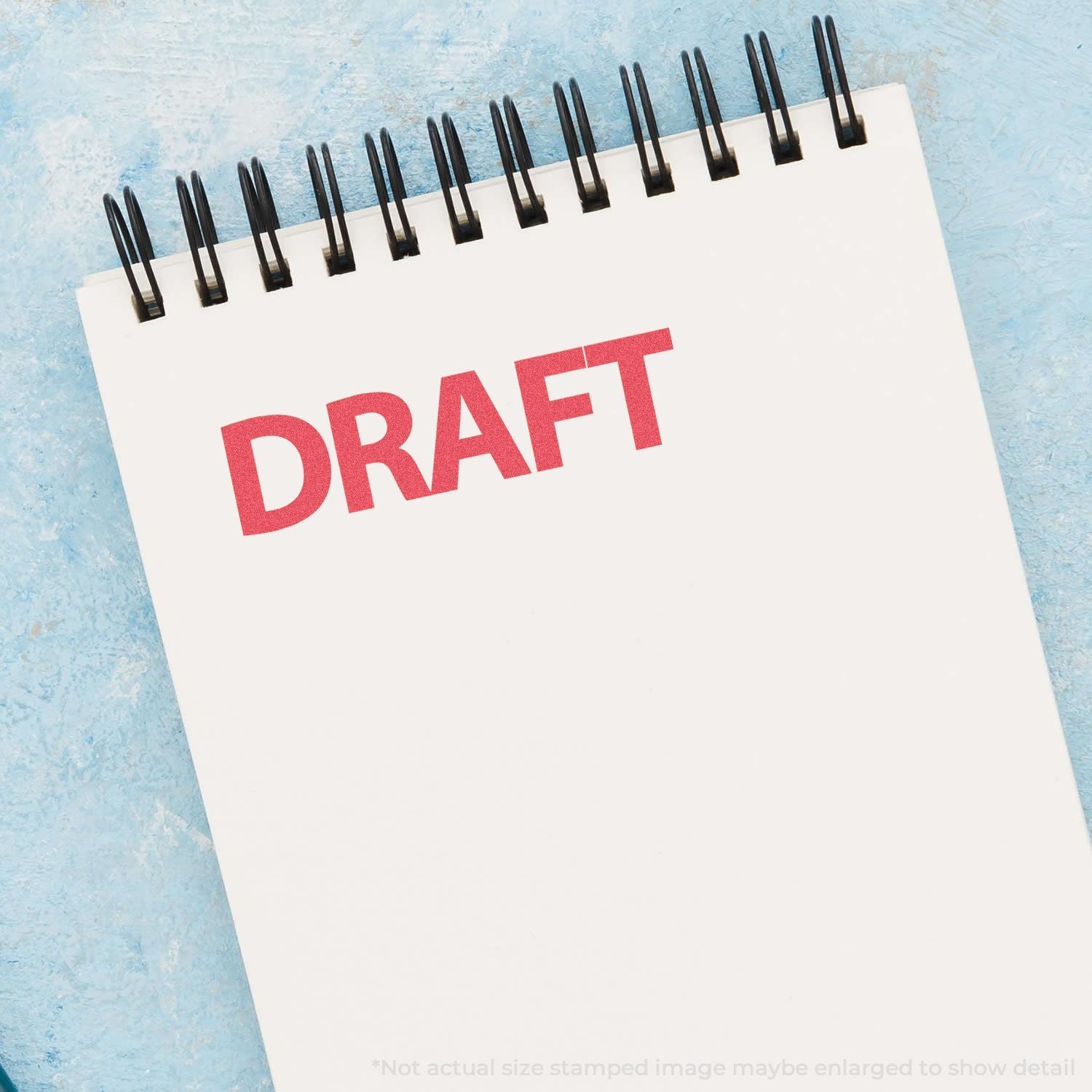 Draft calendar page with red DRAFT title and metal spiral rings on a light blue background.